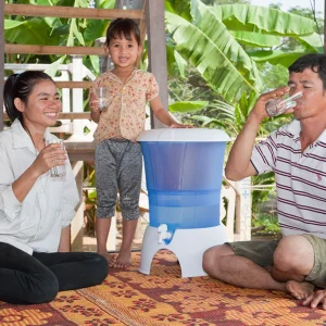 the image shows a family drinking clean filtered water in Southeast Asia
